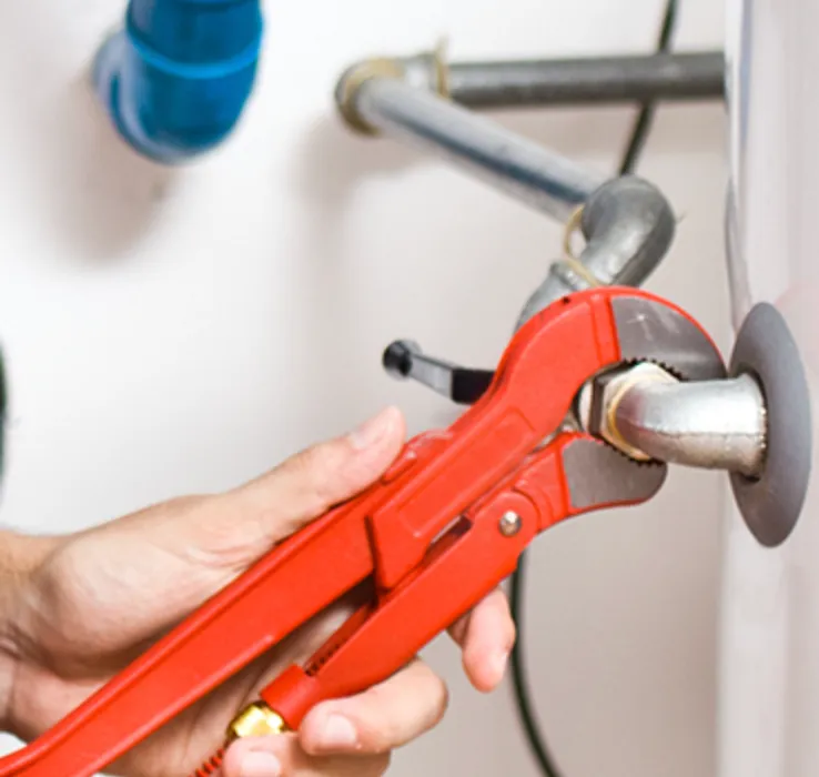 Plumber using a pipe wrench to tighten a fitting