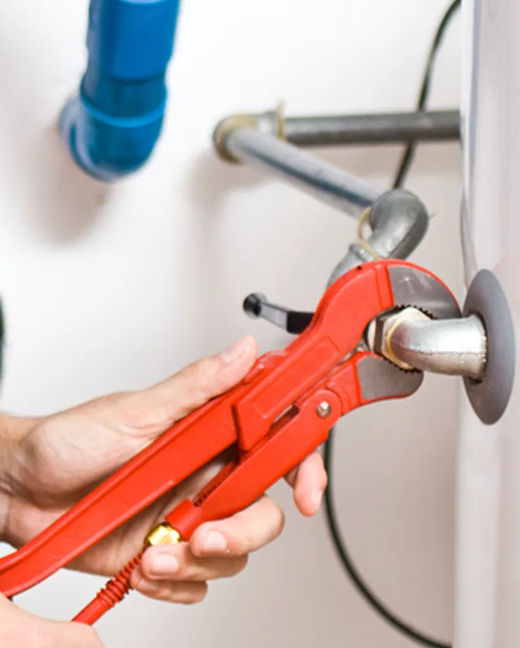 Plumber using a pipe wrench to tighten a fitting