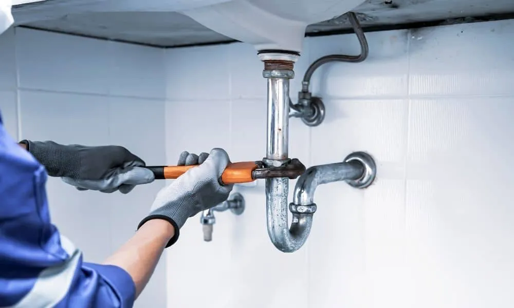 Plumber repairing a sink P-trap and water supply lines